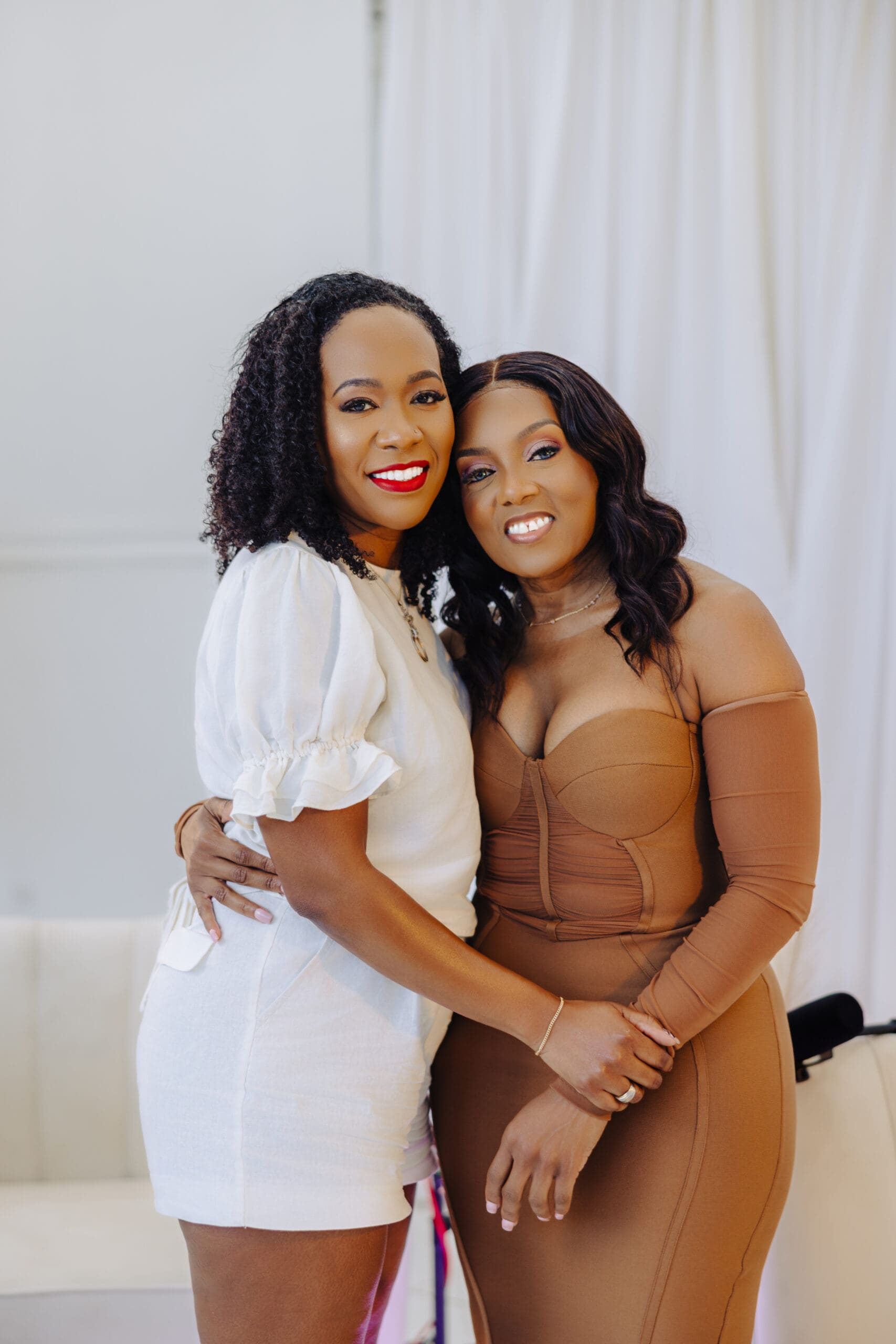 Dr Charmaine Thomas and guest Resha Ruddock smiling and embracing at the Menopause Rebirth Podcast recording.