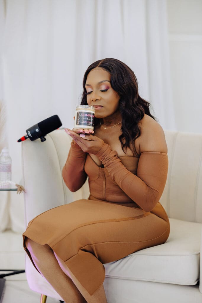Dr Charmaine Thomas with the Confidence candle by Wicks by Grey, featured in Episode 3 of the Menopause Rebirth Podcast.