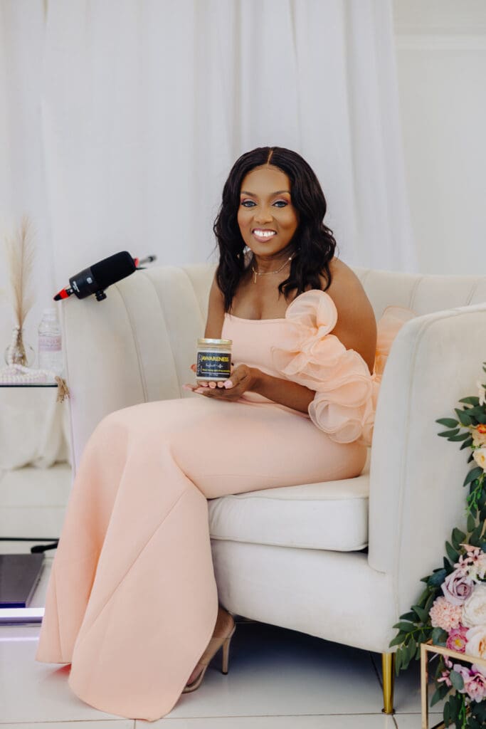 Dr Charmaine Thomas holding the Awareness candle by Wicks by Grey during Episode 4 of the Menopause Rebirth Podcast.